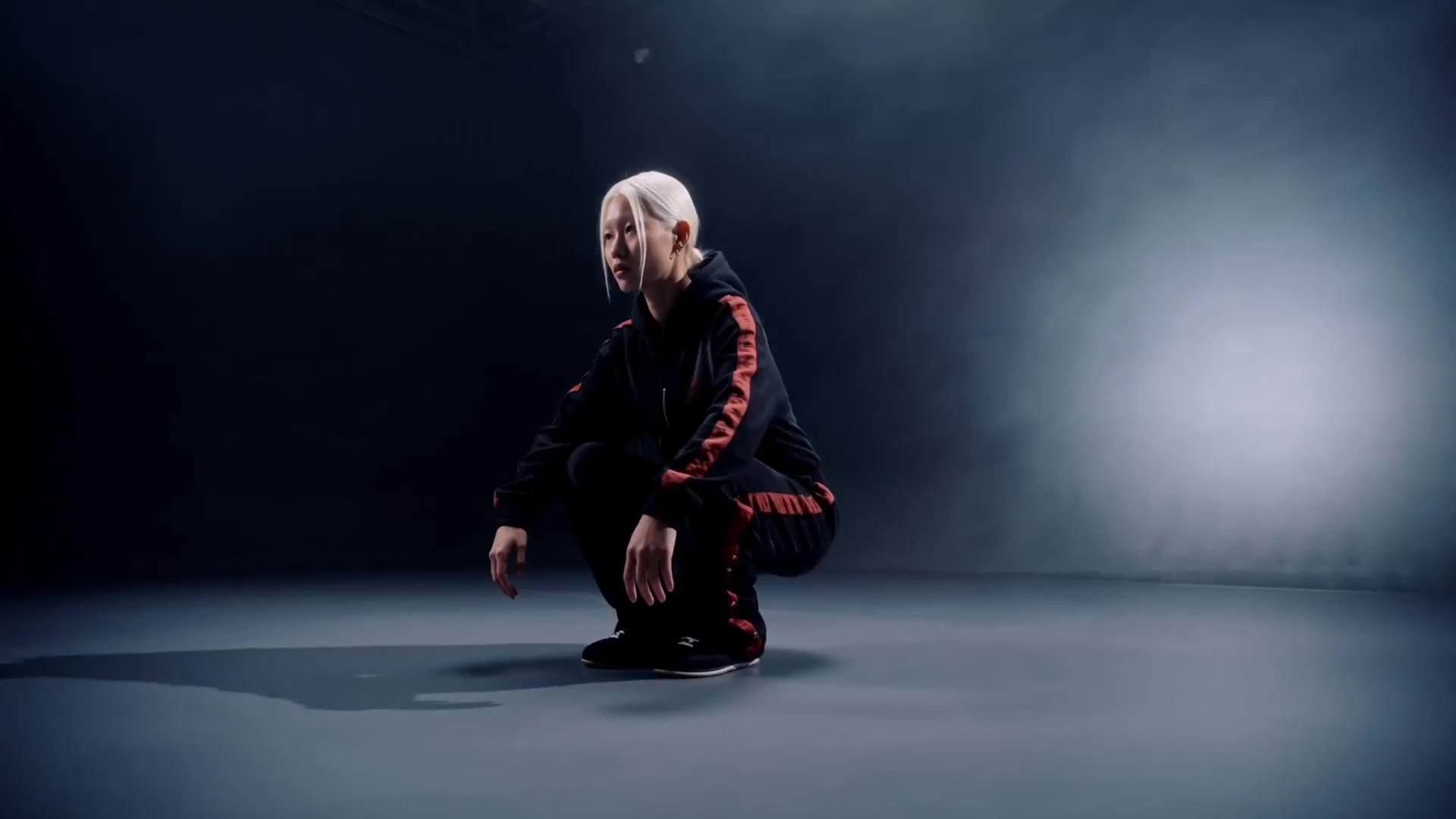 Model crouching under a spotlight